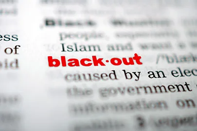 Nahaufnahme des Wortes Blackout in roter Schrift auf einer Wörterbuchseite